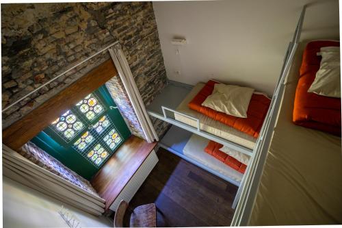 a small room with two beds and a window at Hostel Uppelink in Ghent