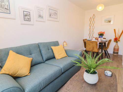 a living room with a blue couch and a table at Pebble Bay in Bideford