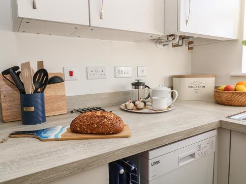 a loaf of bread on a cutting board on a kitchen counter at Pebble Bay in Bideford