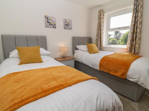 two beds in a bedroom with a window at Pebble Bay in Bideford
