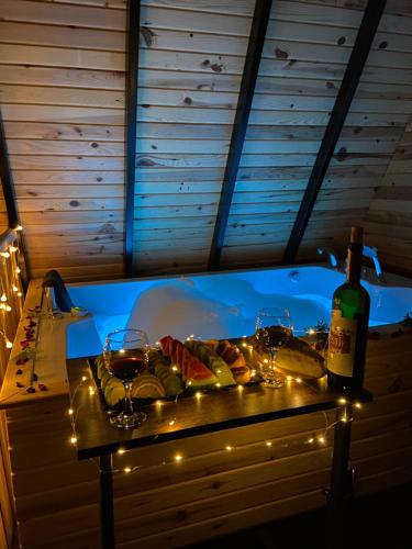 a table with a bottle of wine and wine glasses at Karaöz Sapphire Bungalows in Kumluca