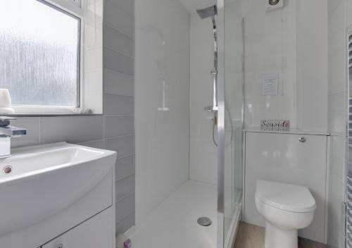 a white bathroom with a toilet and a sink at The Retreat 1 Alexandra Court in Swanage