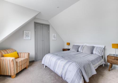 a bedroom with a bed and a chair at The Brackens in Langton Matravers