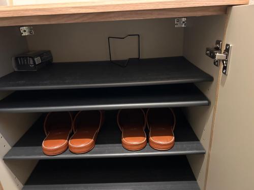 a closet with three pairs of shoes on shelves at 近沙滩 冲浪圣地 鵠沼海岸独立式公寓 独立卫生间 带厨房 有洗衣机 in Fujisawa