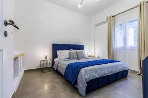 a bedroom with a blue bed and a window at Servani Apartment in Skopelos Town