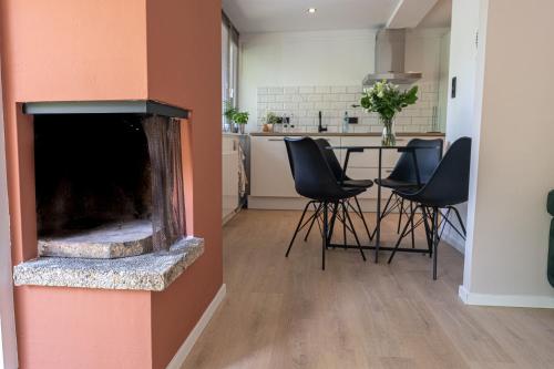a living room with a fireplace and some chairs at 't Bunga huiske in Lanaken