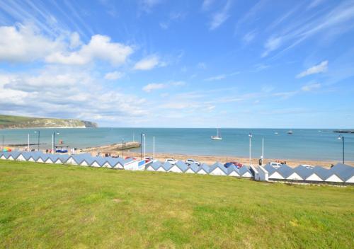 vistas a una playa con una fila de tiendas de campaña en Flat 1 Deco, en Swanage