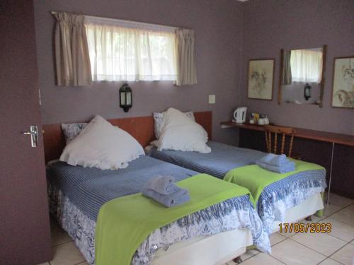 ein Schlafzimmer mit 2 Betten und Handtüchern darauf in der Unterkunft Lutea Guest House in Mokopane