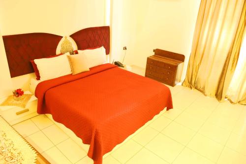 a bedroom with a red bed with a red blanket at Royal Garden Hotel in Beirut