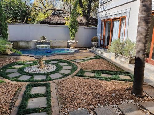 a garden with a fountain in the middle of a yard at Troas Boutique hotel in Vanderbijlpark