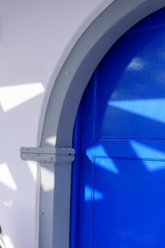 a blue door next to a white wall at Casa Delle Botti Cave House Santorini Oia Finikia in Foinikiá