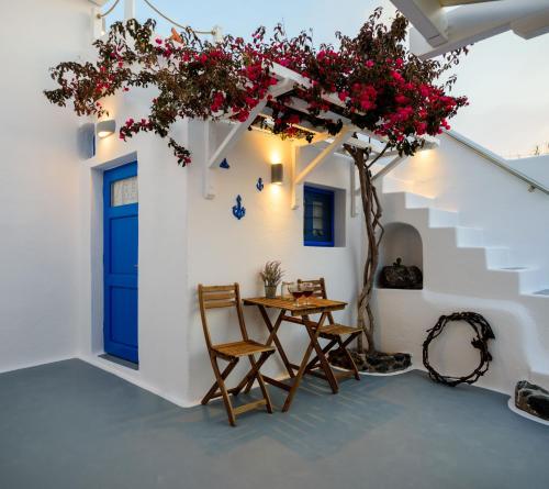 a room with a blue door and a table and chairs at Casa Delle Botti Cave House Santorini Oia Finikia in Foinikiá