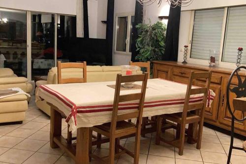 einen Esstisch und Stühle mit einem Tisch und einem Sofa in der Unterkunft Villa avec piscine et vue magnifique sur Nice in Nizza