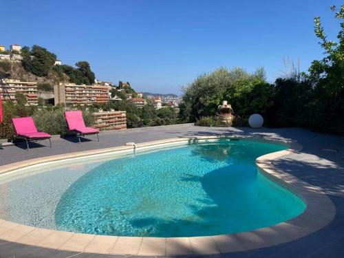 - une grande piscine d'eau bleue dans la cour dans l'établissement Villa avec piscine et vue magnifique sur Nice, à Nice