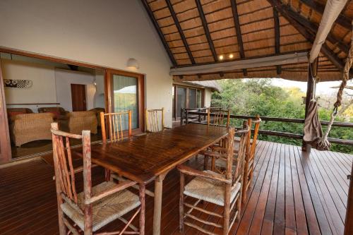 a wooden table and chairs on a deck at Nyati Safari Lodge in Hoedspruit
