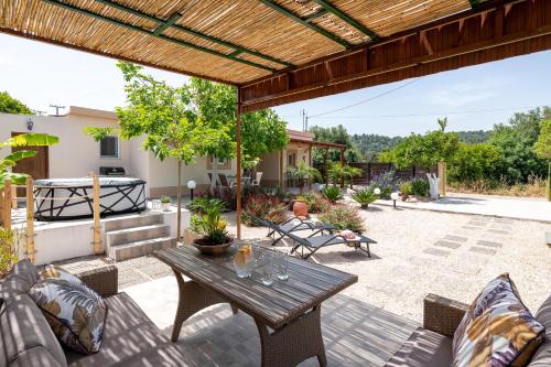 un patio al aire libre con mesa de madera y sillas en Mikros Paradeisos en Theologos