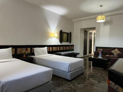 una camera d'albergo con due letti e un divano di Ourida Urban Hotel Rabat a Rabat