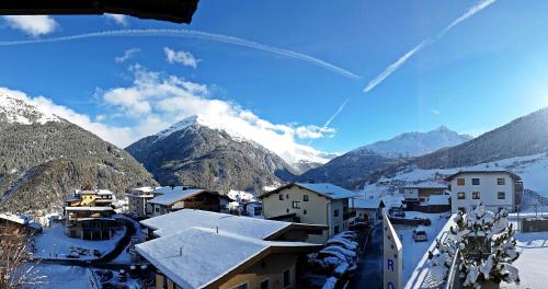 a village in the mountains with snow on the roofs at Royal Appartements Sölden in Sölden