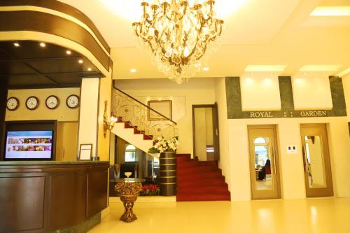 a lobby with a chandelier and stairs in a building at Royal Garden Hotel in Beirut