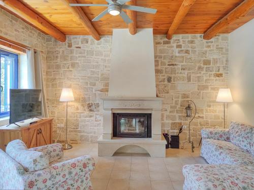 a living room with a fireplace and a ceiling fan at Lemon Tree Villa with Private Pool and Starlink Internet in Frés