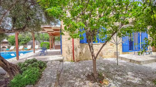 a building with a tree and a swimming pool at Lemon Tree Villa with Private Pool and Starlink Internet in Frés