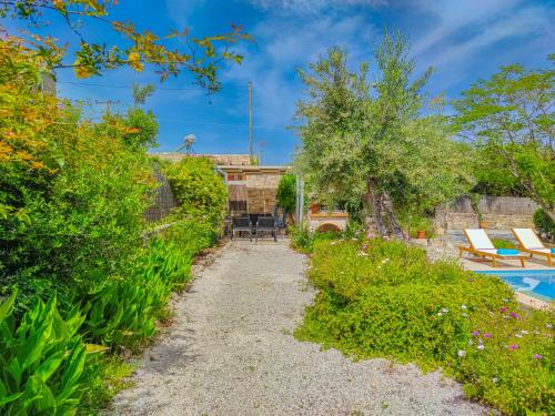 a path leading to a garden with a swimming pool at Lemon Tree Villa with Private Pool and Starlink Internet in Frés