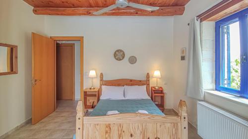 a bedroom with a wooden bed and a window at Lemon Tree Villa with Private Pool and Starlink Internet in Frés