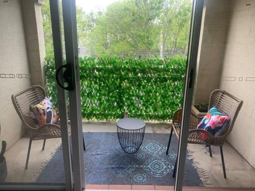 a patio with two chairs and a table and a glass door at Plush 2 bedroom apartment Kingston in Kingston 