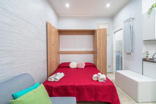 ein Schlafzimmer mit einem roten Bett mit Puppen drauf in der Unterkunft Dimora D&G in Syrakus