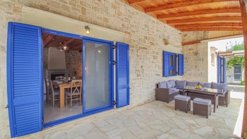 a patio with blue doors and a table and chairs at Lemon Tree Villa with Private Pool and Starlink Internet in Frés