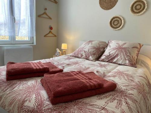 un lit avec des couvertures rouges dessus dans une chambre dans l'établissement Charmante maison avec cour privative, à Cognac