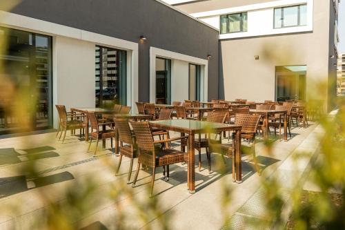 デュッセルドルフにあるNovotel Duesseldorf Airportのテーブルと椅子が置かれた空きレストランです。