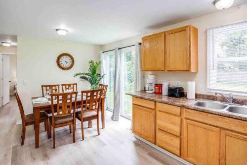 una cocina con armarios de madera, mesa y sillas en ~Cozy Home~ Steps to RIT by UofR/Airport/DWTN w/AC en Rochester