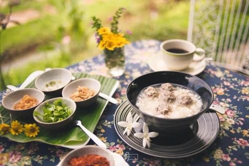 einen Tisch mit einer Schüssel Essen und einer Tasse Kaffee in der Unterkunft Lhongkhao Samoeng By Chivilla 