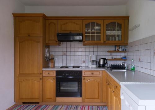 a kitchen with wooden cabinets and a stove top oven at Ganhör- Fam. Kaar in Wintersdorf