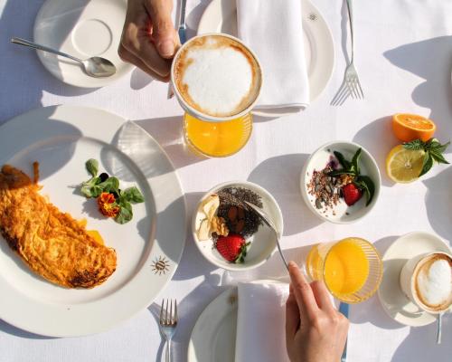 a table topped with plates of food and a drink at Jesolopalace Hotel & Aparthotel in Lido di Jesolo