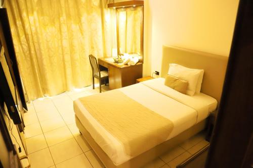 a bedroom with a bed and a desk and a table at Royal Garden Hotel in Beirut