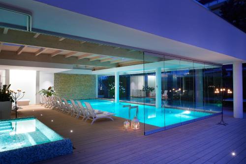 a house with a swimming pool and a deck at Jesolopalace Hotel & Aparthotel in Lido di Jesolo