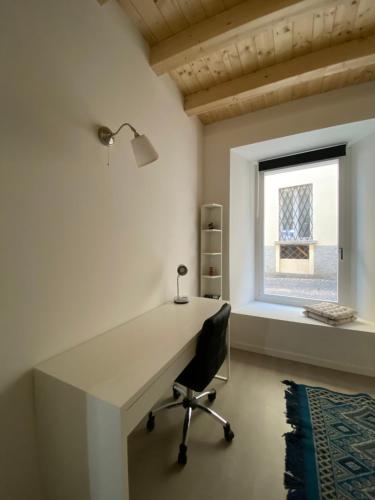 escritorio en una habitación con silla y ventana en Casa da Raquel, en Lecco