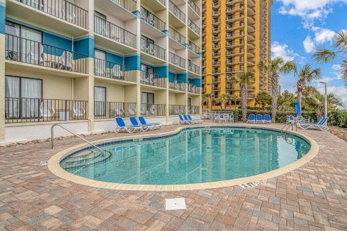 einen Pool in einem Resort mit Stühlen und einem Gebäude in der Unterkunft Oceanfront 2 Bedroom Suite with Incredible Views! Carolinian 630 in Myrtle Beach