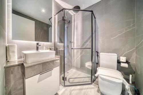 a bathroom with a shower and a toilet and a sink at Pleasant 2BR with Assistant Room at Mesk 1 Midtown Dubai Production City by Deluxe Holiday Homes in Dubai