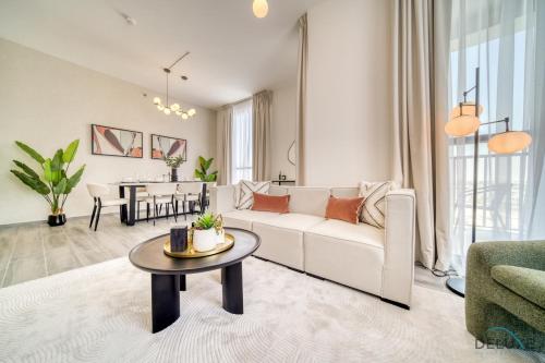 a living room with a white couch and a table at Pleasant 2BR with Assistant Room at Mesk 1 Midtown Dubai Production City by Deluxe Holiday Homes in Dubai