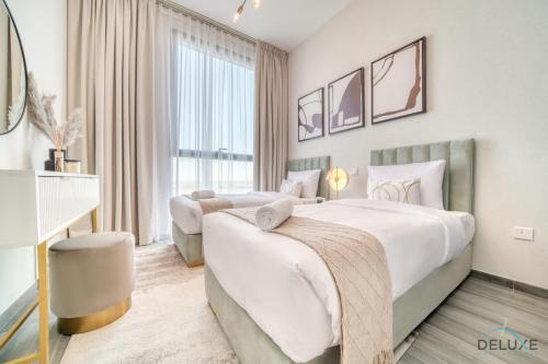 a bedroom with two beds and a large window at Pleasant 2BR with Assistant Room at Mesk 1 Midtown Dubai Production City by Deluxe Holiday Homes in Dubai