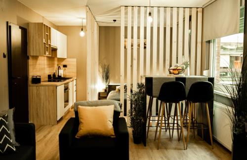 una cucina e un soggiorno con tavolo di Black Velvet Apartman a Sisak