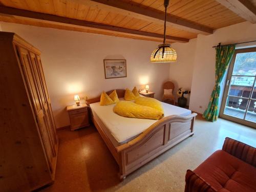Un dormitorio con una cama con una manta amarilla. en Lauchlehen, en Bischofswiesen