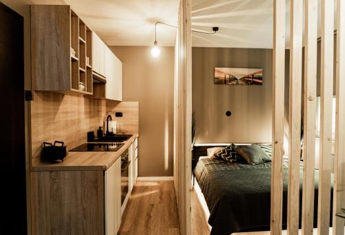 una pequeña cocina con cama y lavabo en una habitación en Black Velvet Apartman en Sisak