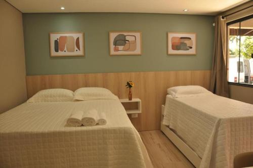 a bedroom with two beds with towels on them at POUSADA DELVILLE in Itapoa