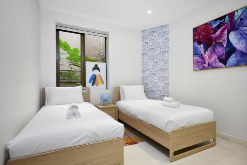 een slaapkamer met 2 bedden en een schilderij aan de muur bij Bourke Street Urban Retreat in Melbourne