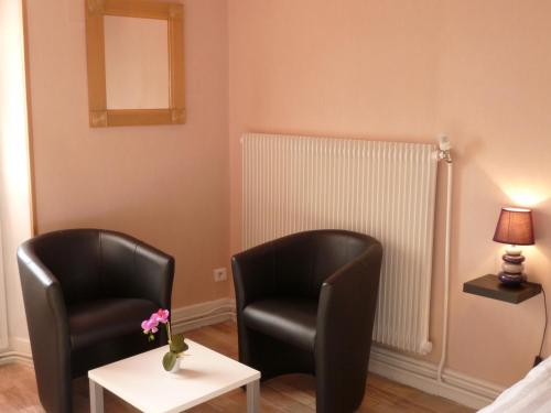 two chairs in a room with a table and a lamp at Hotel Le Beauregard in Divonne-les-Bains