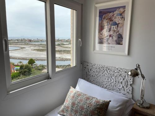 1 dormitorio con 1 cama y 2 ventanas en Mirando a dos mares, en La Manga del Mar Menor